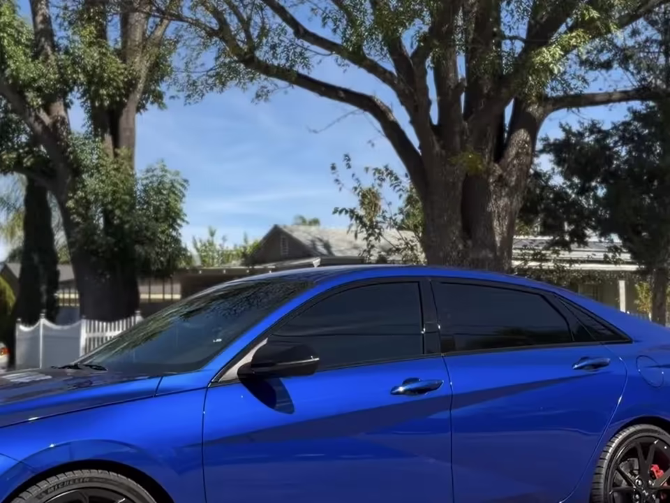 Blue sedan with dark ceramic tint on all windows